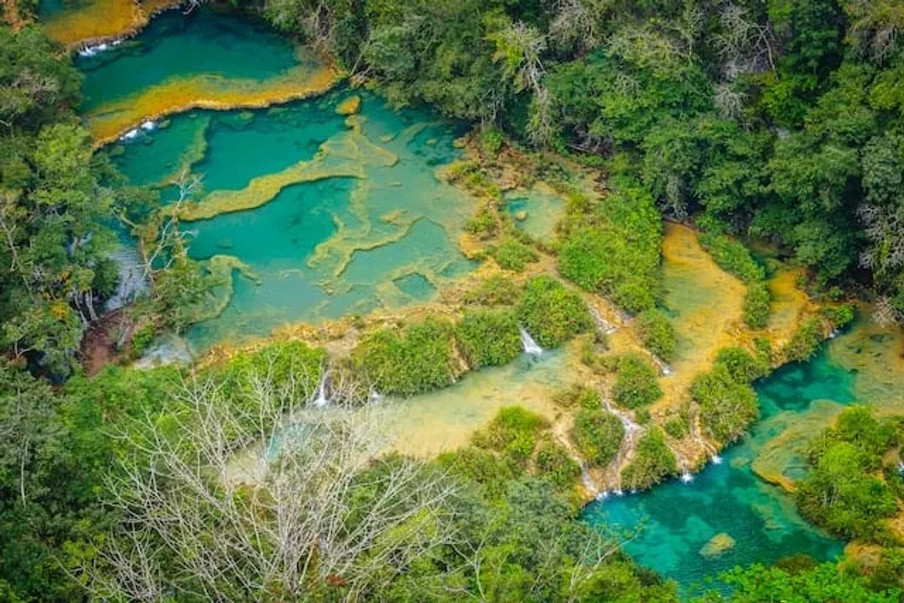 água azul turquesa com arbustos verdes em Lanquen, Guatemala