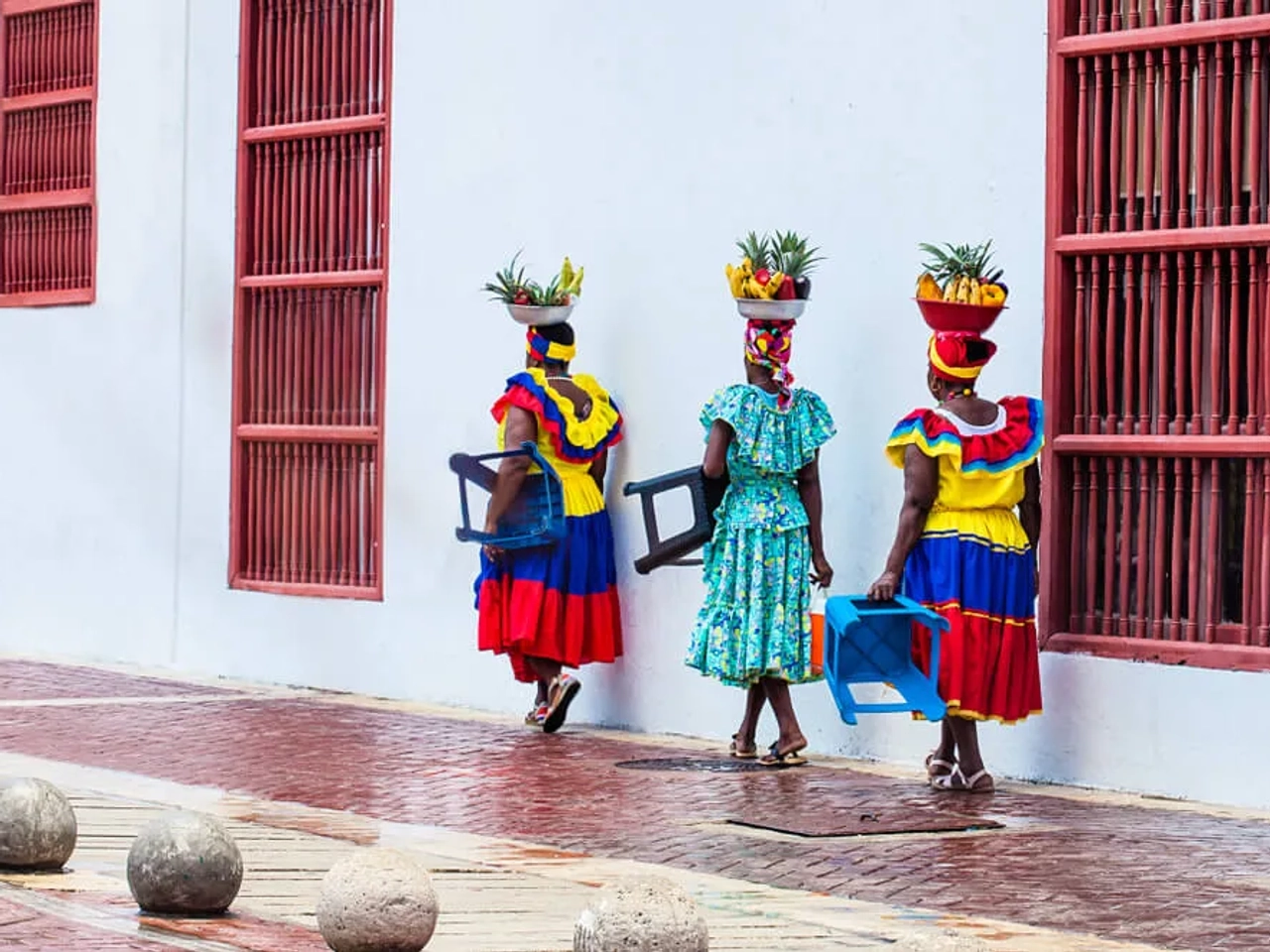 mulheres colombianas com fruta na cabeça e vestidos tradicionais