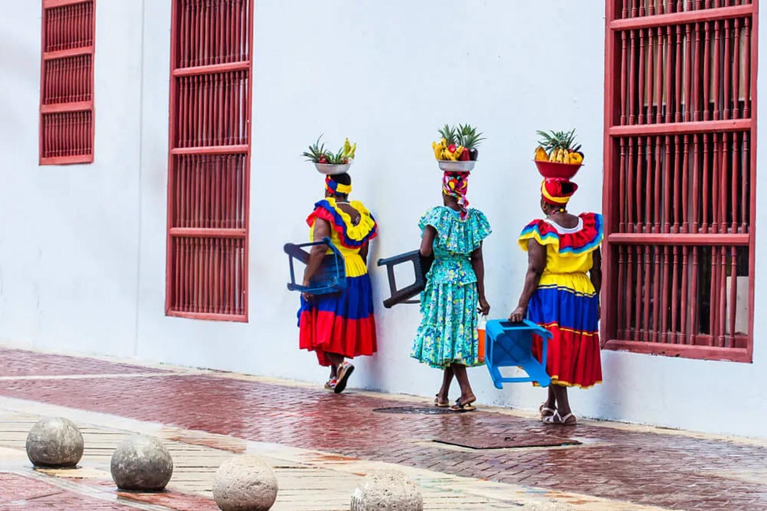 mulheres colombianas com fruta na cabeça e vestidos tradicionais