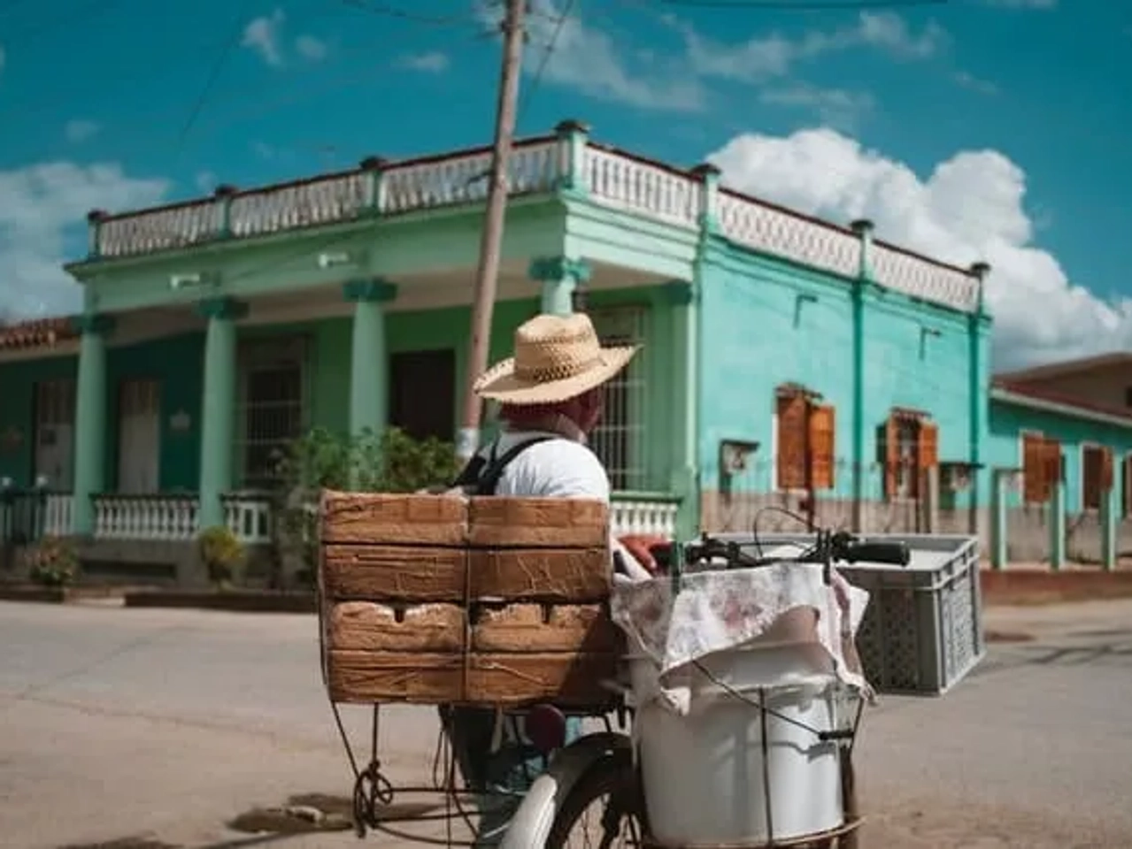 pessoa com chapéu a andar de bicicleta durante o dia