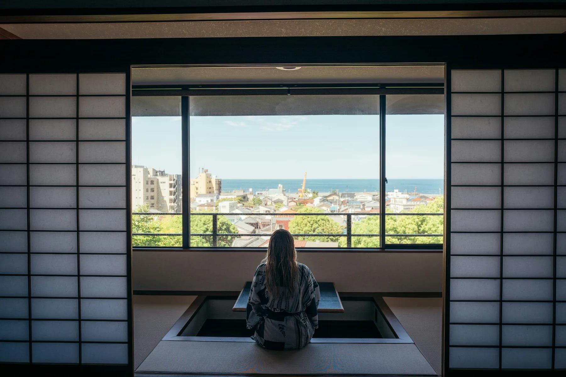 Viaggiatrice in una stanza di un ryokan tradizionale in Giappone, esempio di alloggio durante il viaggio.