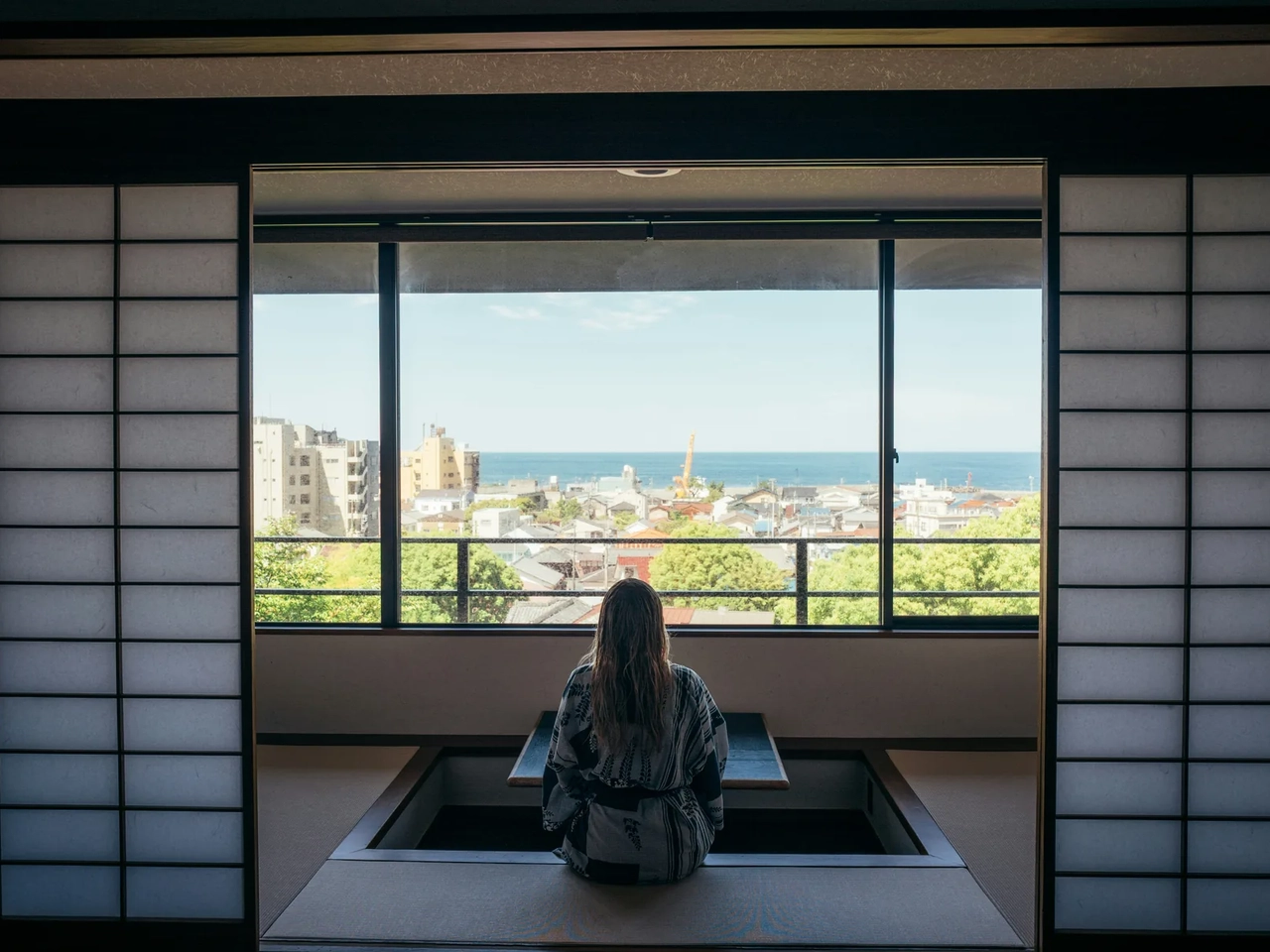 Viaggiatrice in una stanza di un ryokan tradizionale in Giappone, esempio di alloggio durante il viaggio.