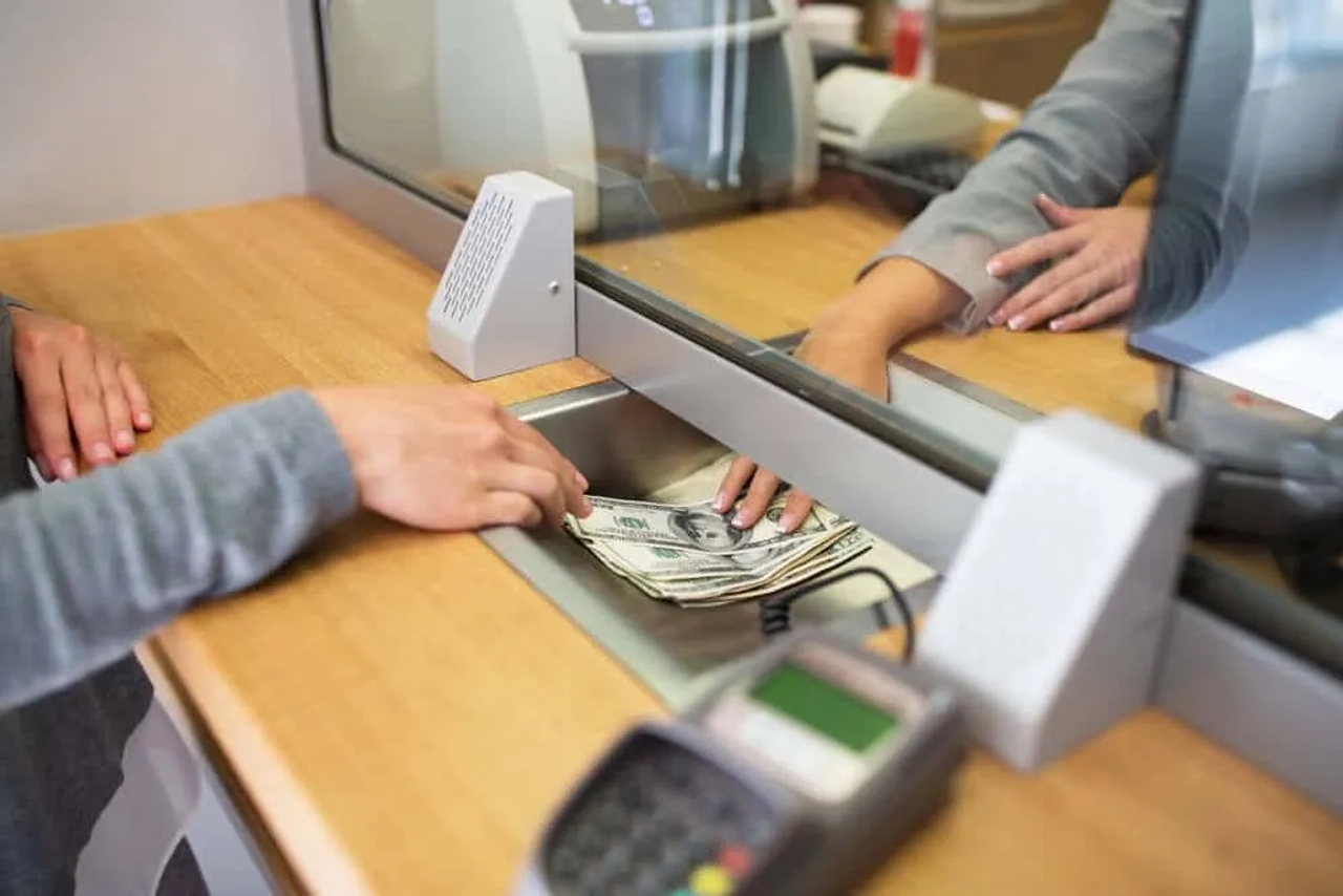 pessoa a cambiar dinheiro num banco