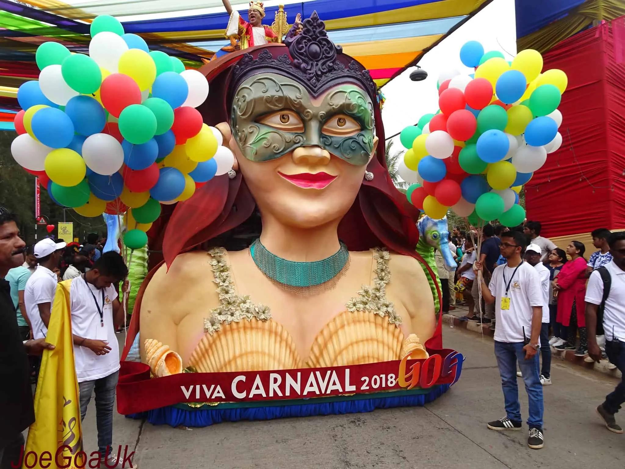 Desfile de Carnaval com carro alegórico e balões coloridos em ambiente festivo.