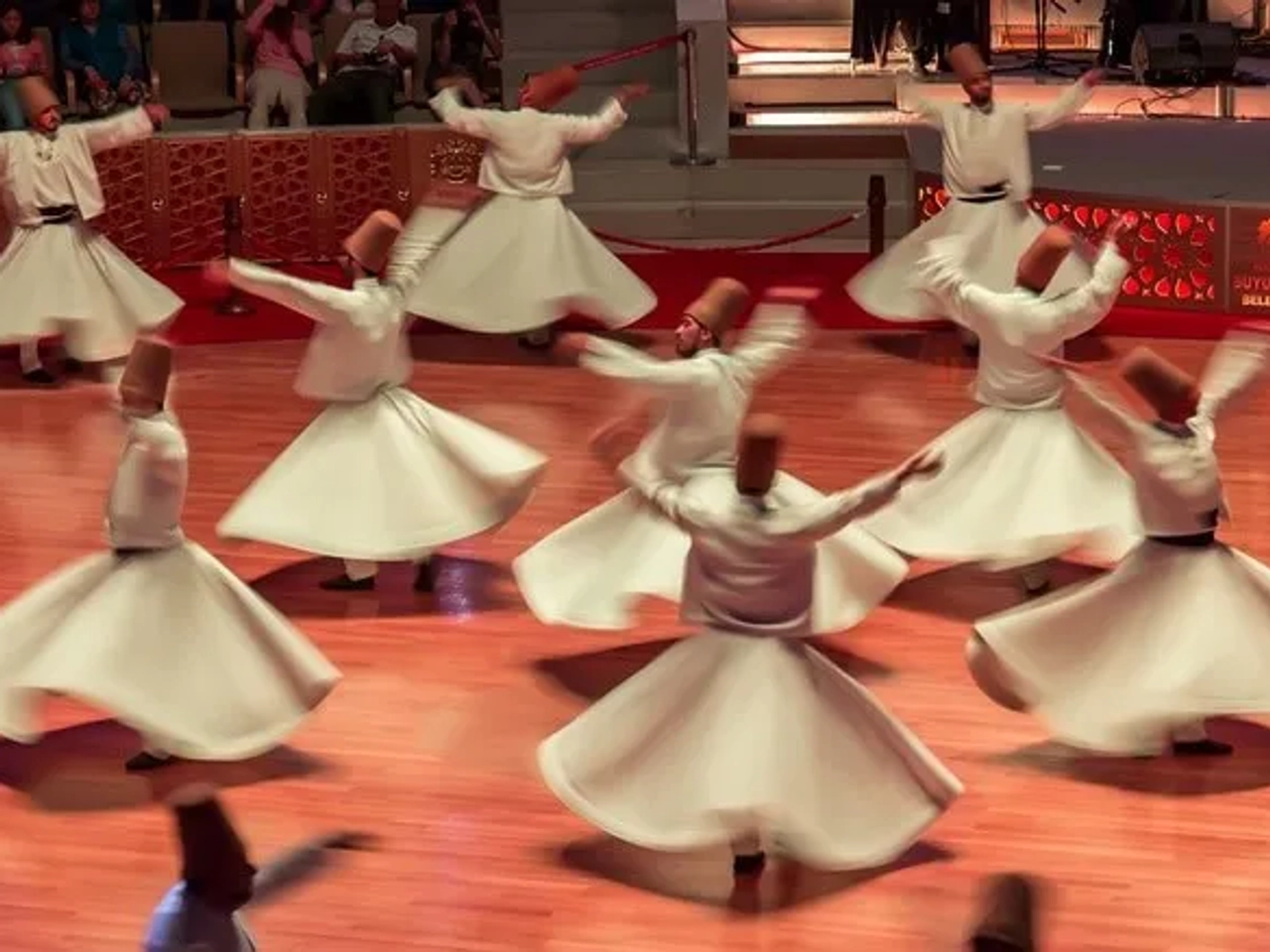 Derviches giradores en un espectáculo cultural en Turquía. Movimiento y tradición.