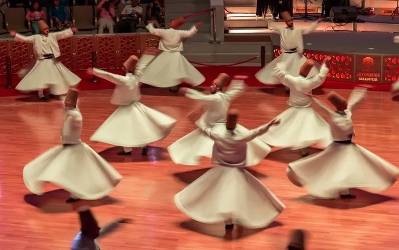 Derviches giradores en un espectáculo cultural en Turquía. Movimiento y tradición.