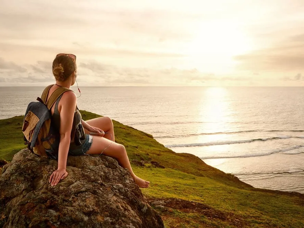 mulher a olhar para o horizonte sentada numa arriba
