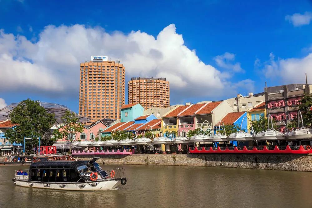 um barco navega em frente ao boat quay
