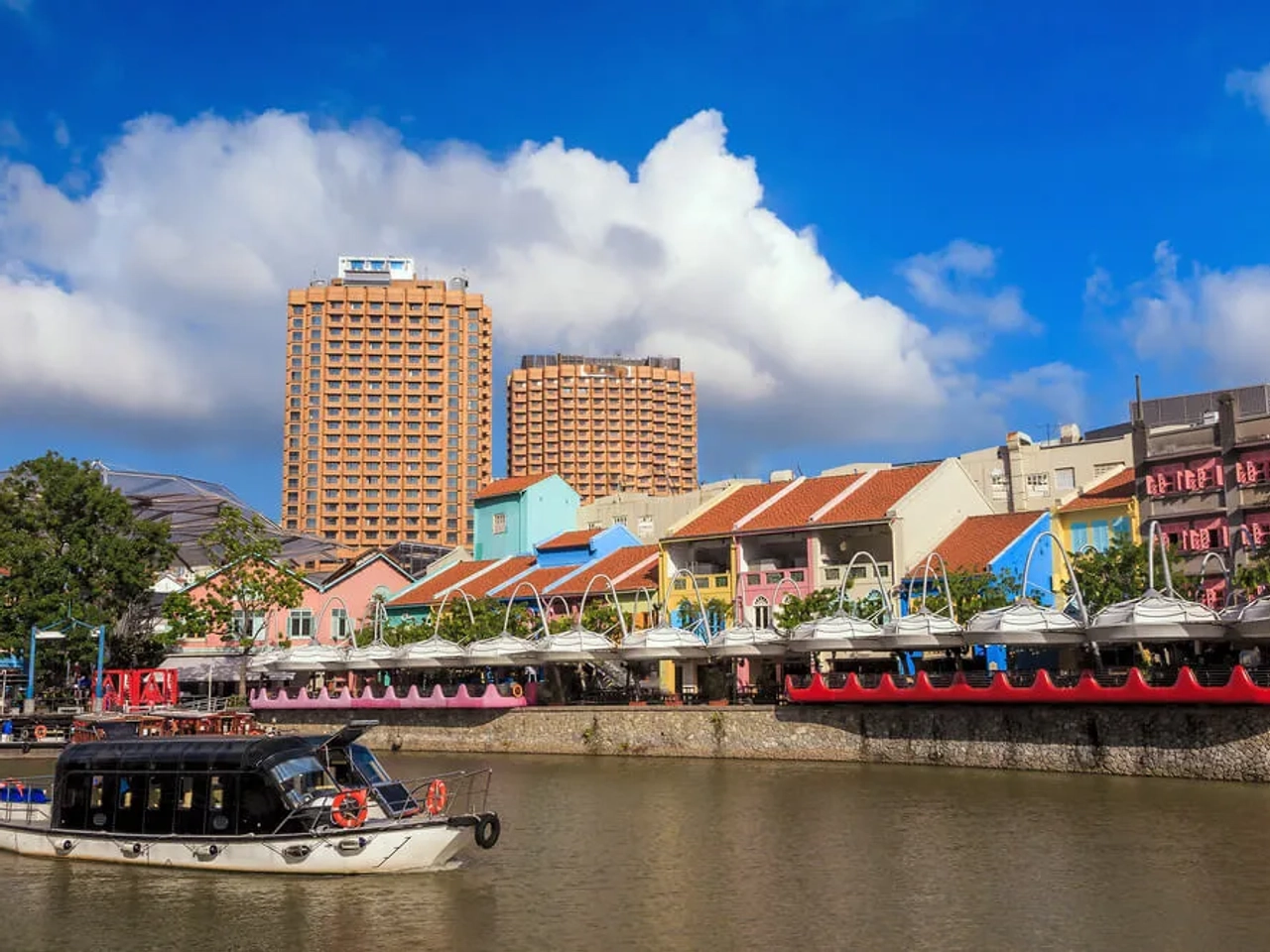um barco navega em frente ao boat quay