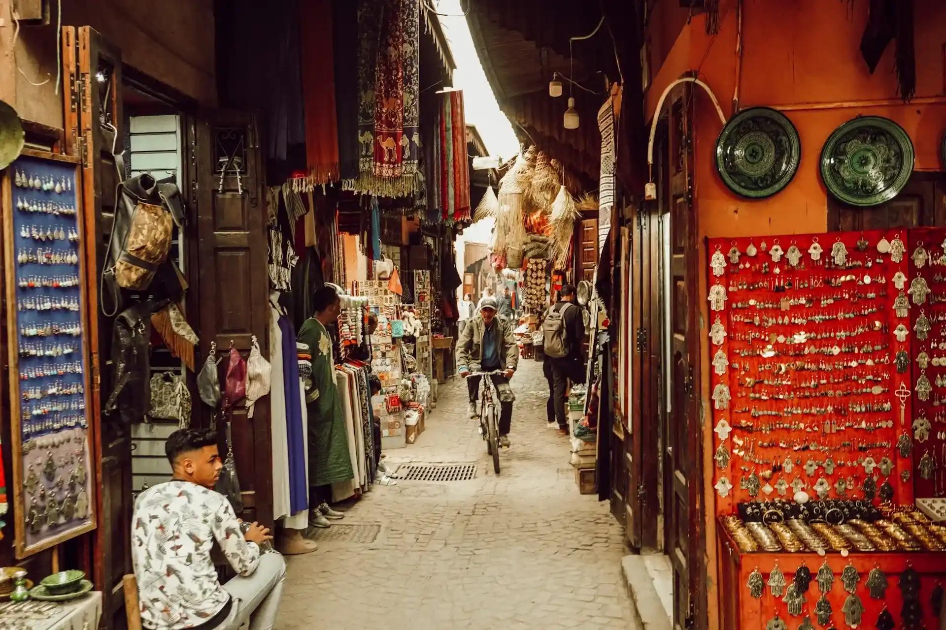 Medina in Marocco con souk, negozi di artigianato e passanti, immagine per consigli sulla sicurezza durante il viaggio.