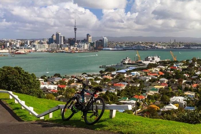 Vista panorámica de Auckland con un bicicleta en primer plano y edificios al fondo.