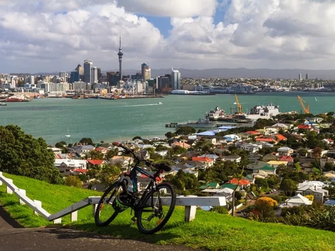 Vista panorámica de Auckland con un bicicleta en primer plano y edificios al fondo.