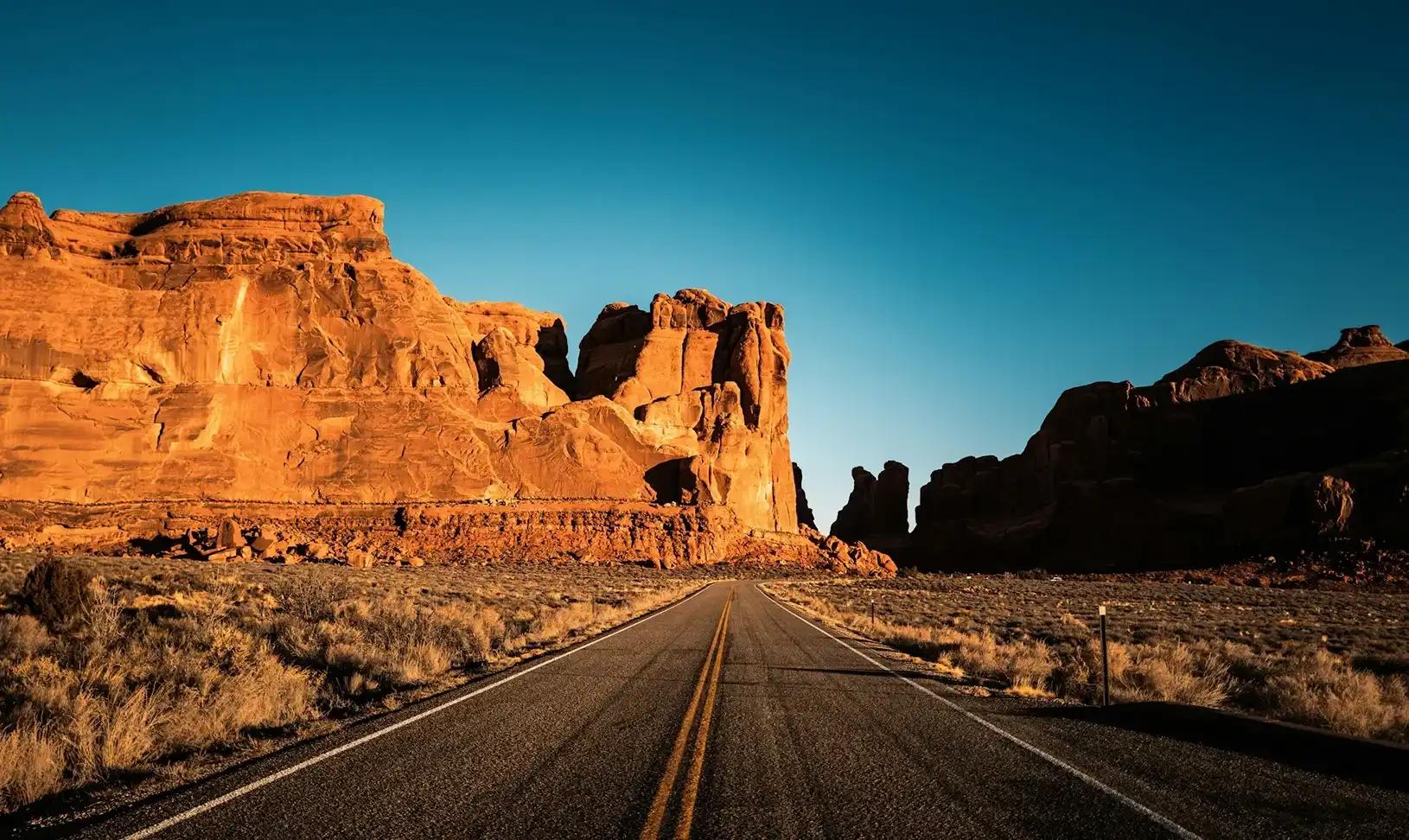 Strada panoramica tra formazioni rocciose nello Utah durante un road trip negli Stati Uniti.