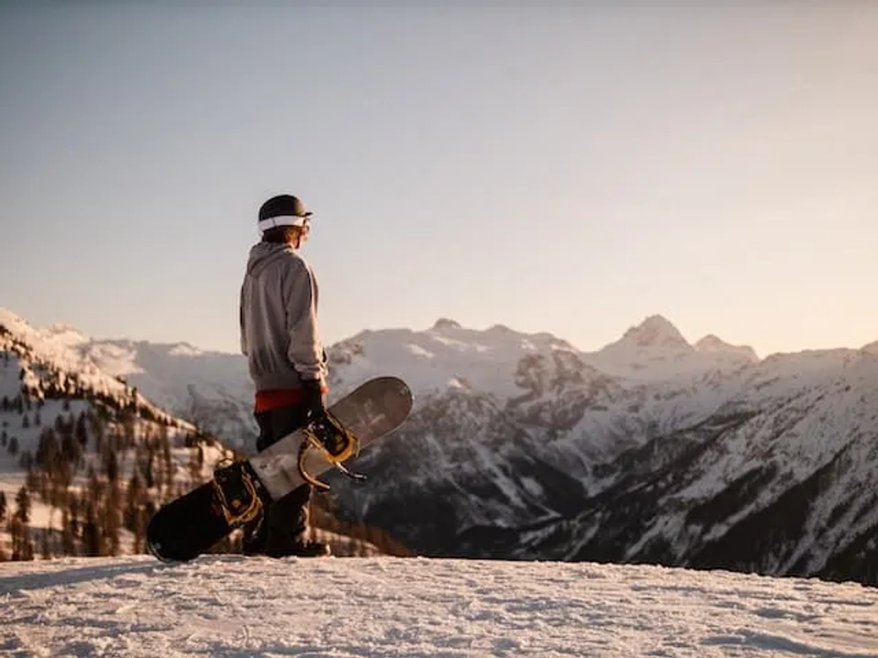 one man holding a snowboard in a mountain