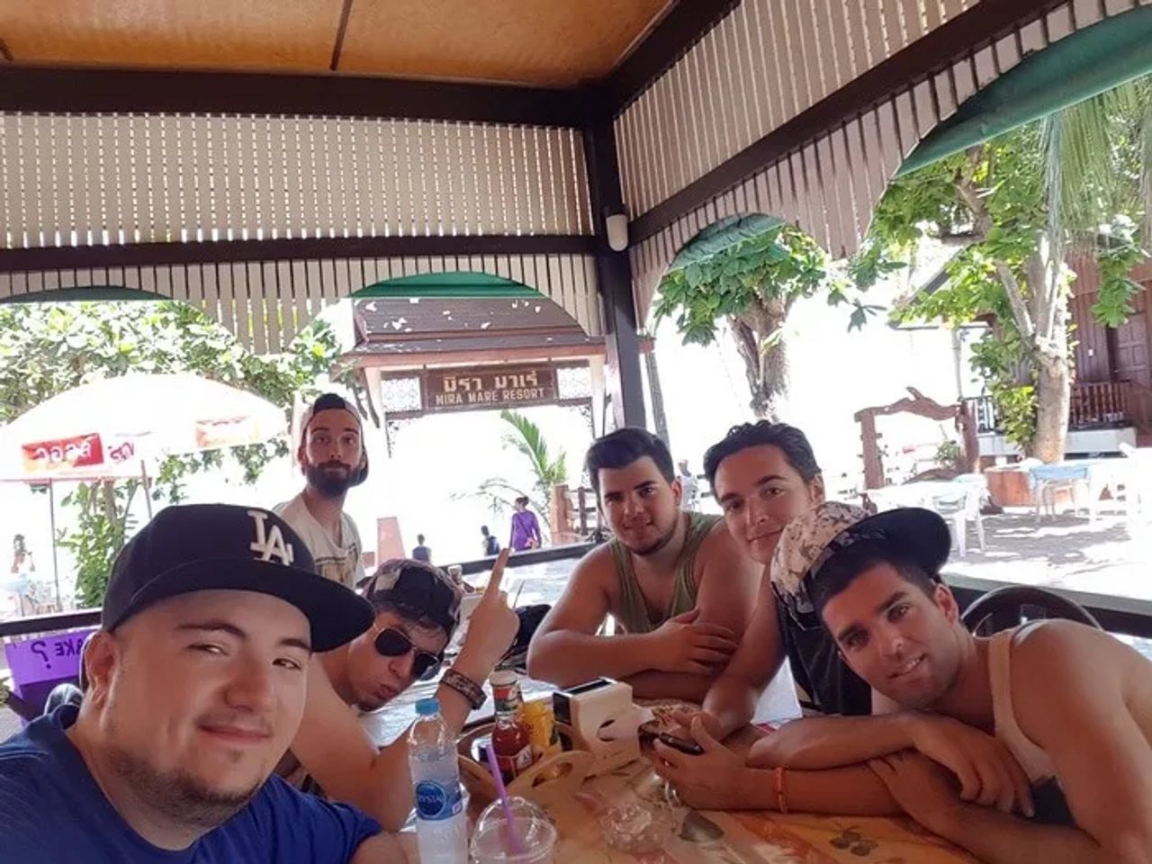 Grupo de amigos en un restaurante al aire libre, disfrutando de un momento juntos.