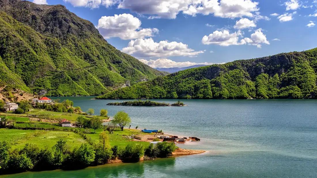unas casas junto a un lago que ver en albania