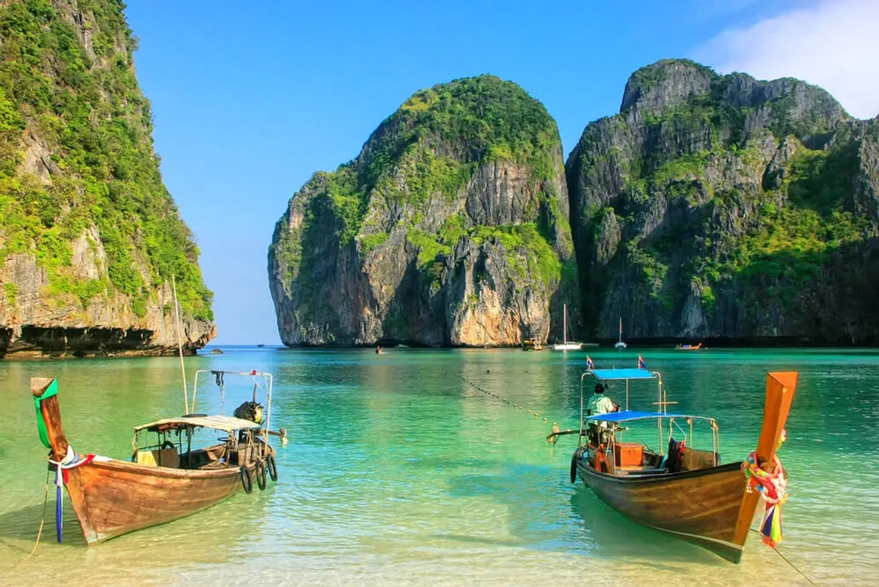 dois barcos numa praia tailandesa num dia solarengo