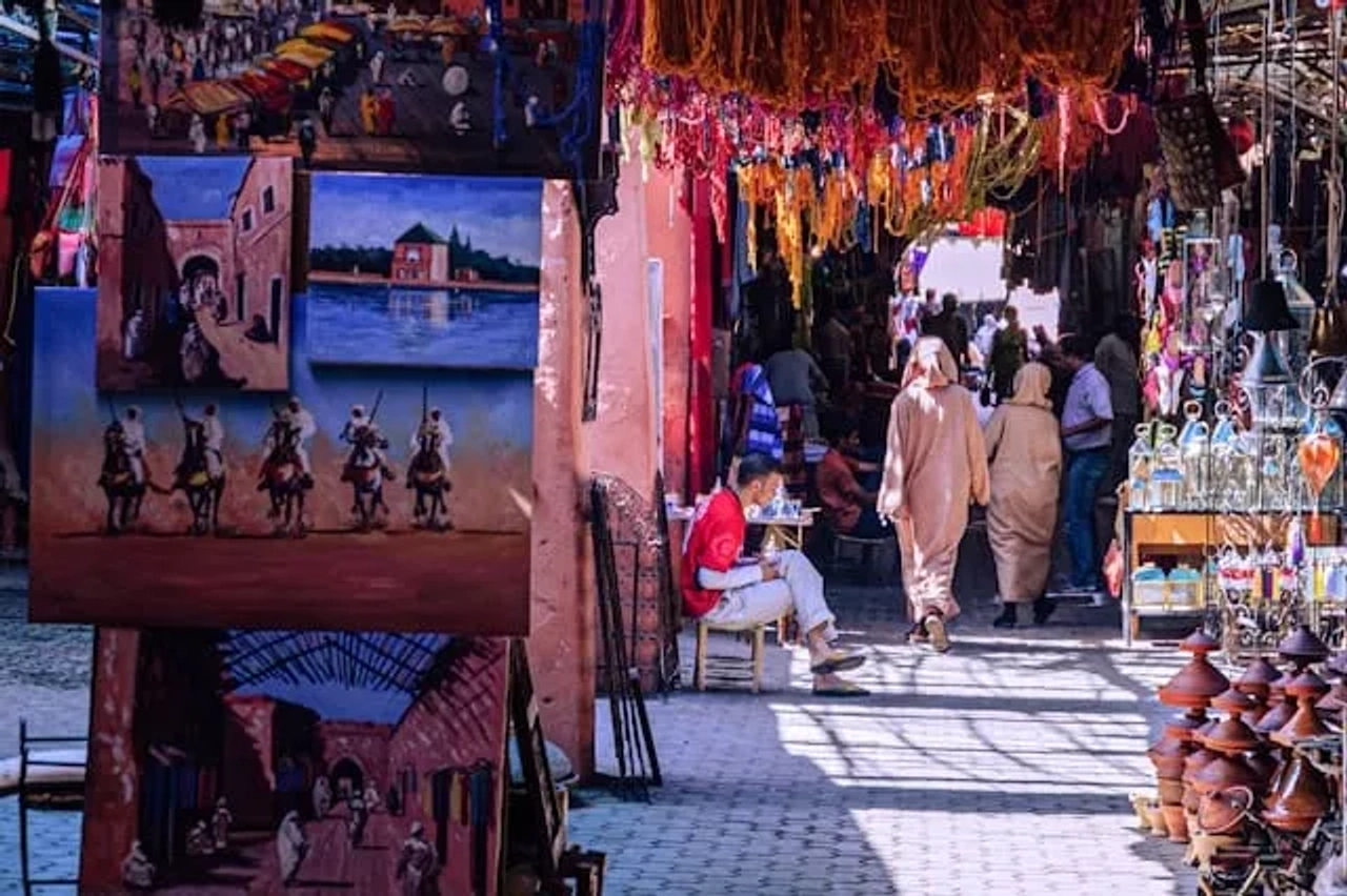 duas pessoas a passear pelo meio de um mercado colorido em marrocos