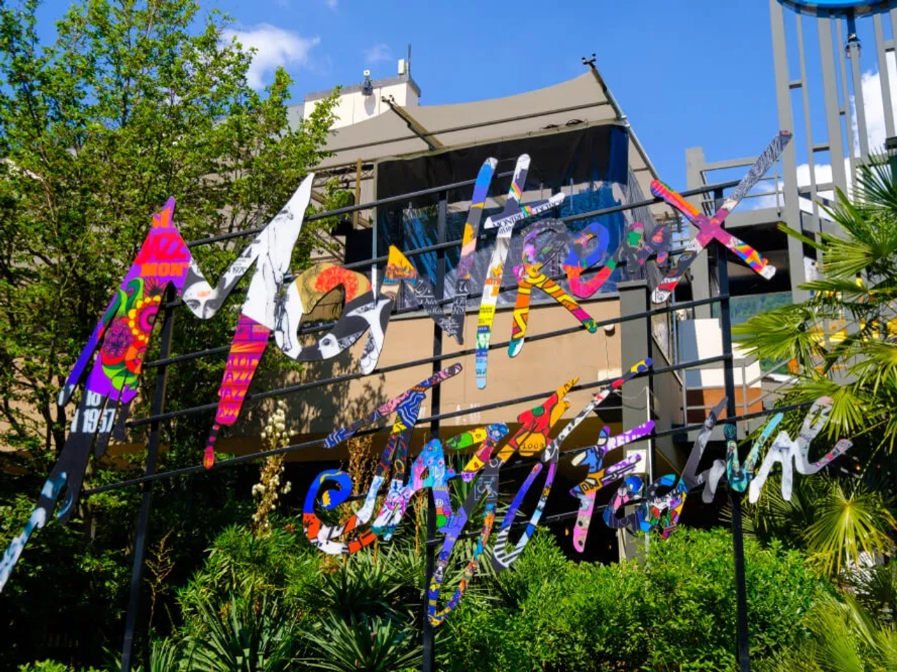 logotipo do festival de jazz pendurado numa varanda com arvores por tras