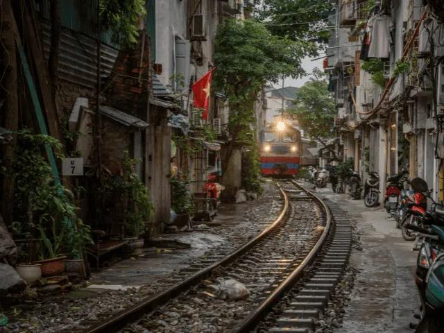 comboio numa linha ferroviaria junto a casas em hanoi no vietname
