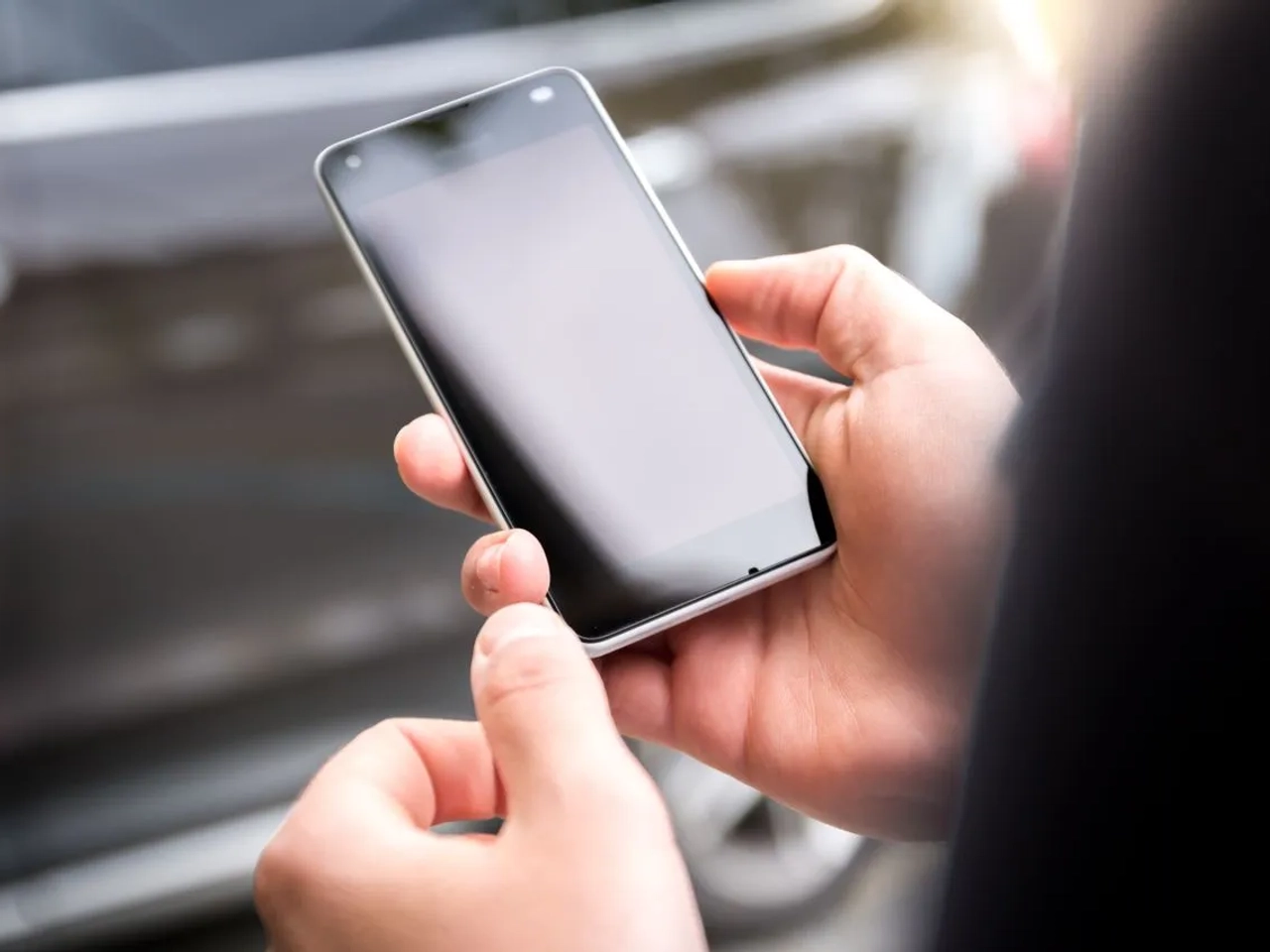 Mani che tengono uno smartphone durante la compilazione dell’ESTA Mobile per un viaggio negli Stati Uniti.