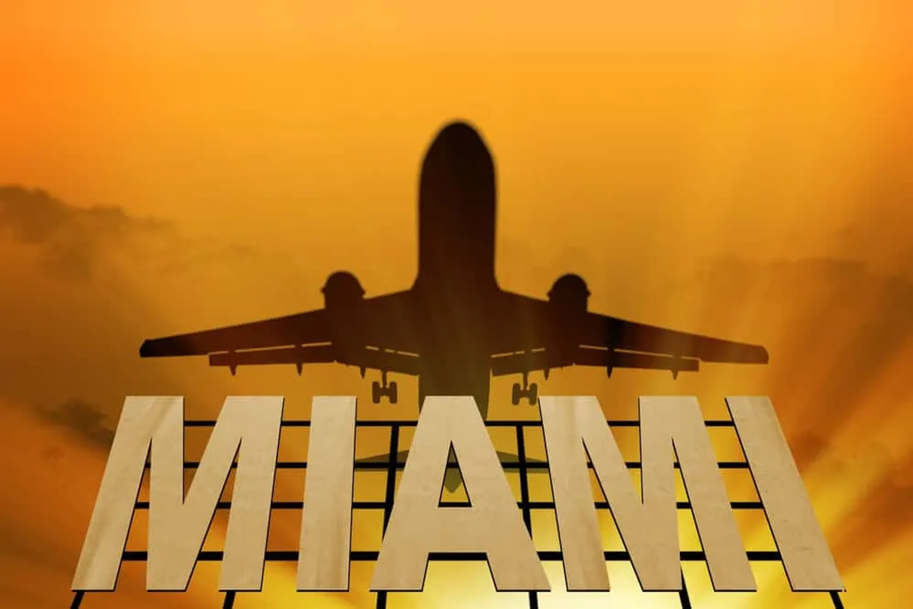 aviao sobre letreiro de miami
