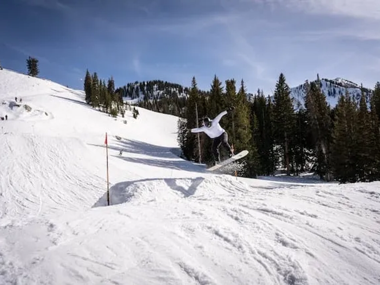 rapaz a fazer snowboard ea saltar numa rampa em Brighton, UT, USA
