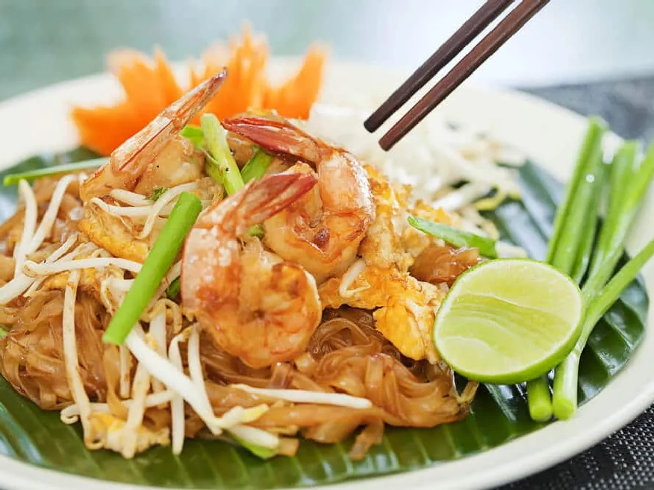 prato de comida tailandesa com pauzinhos ao fundo