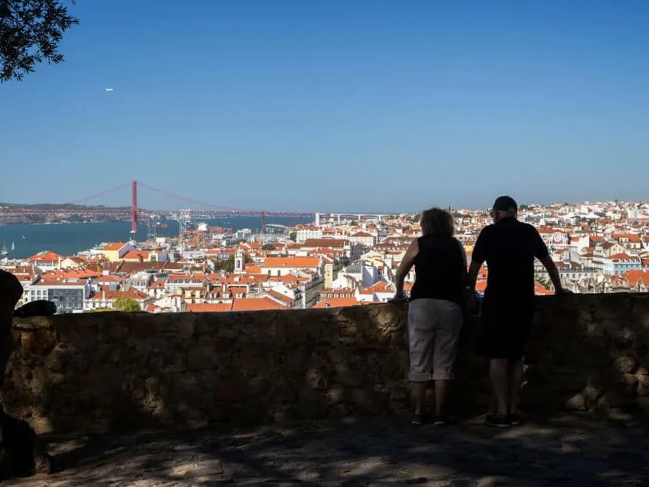 casal observa lisboa desde o miradouro doo castelo de sao jorge