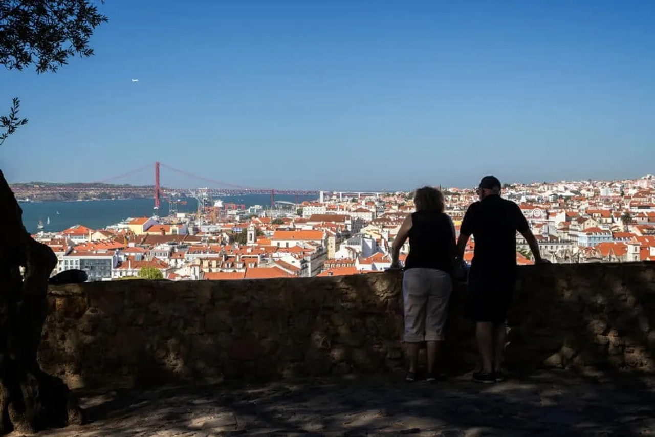 casal observa lisboa desde o miradouro doo castelo de sao jorge