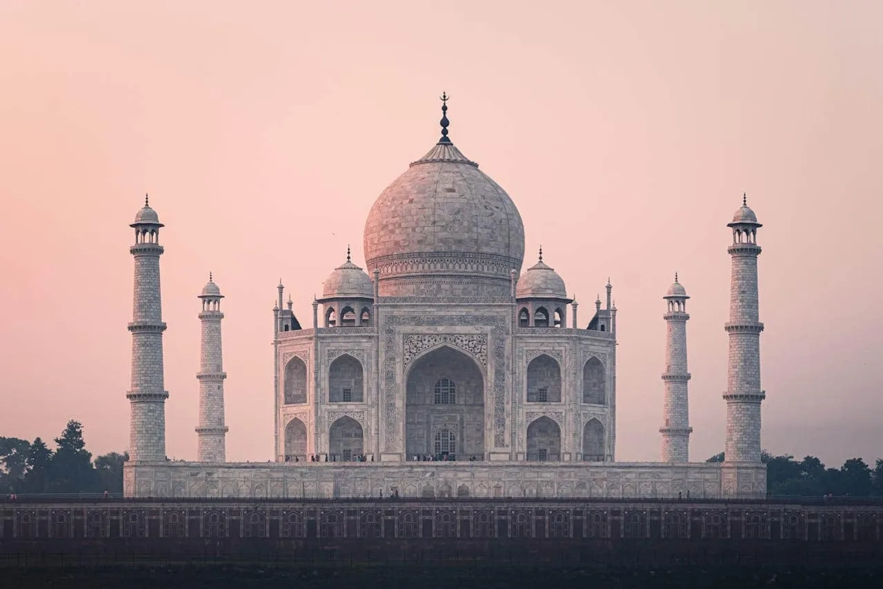 Taj Mahal, mausoléu icônico, cercado por minaretes e jardins.