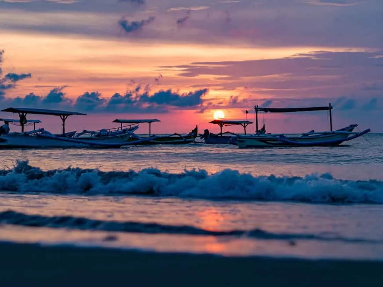 barcos tradicionais balineses a navegar ao por do sol