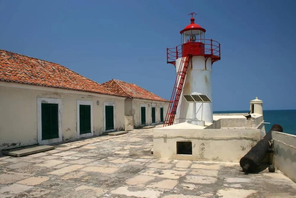 farol vermelho e branco e casas no interior doe forte de sao sebastiao