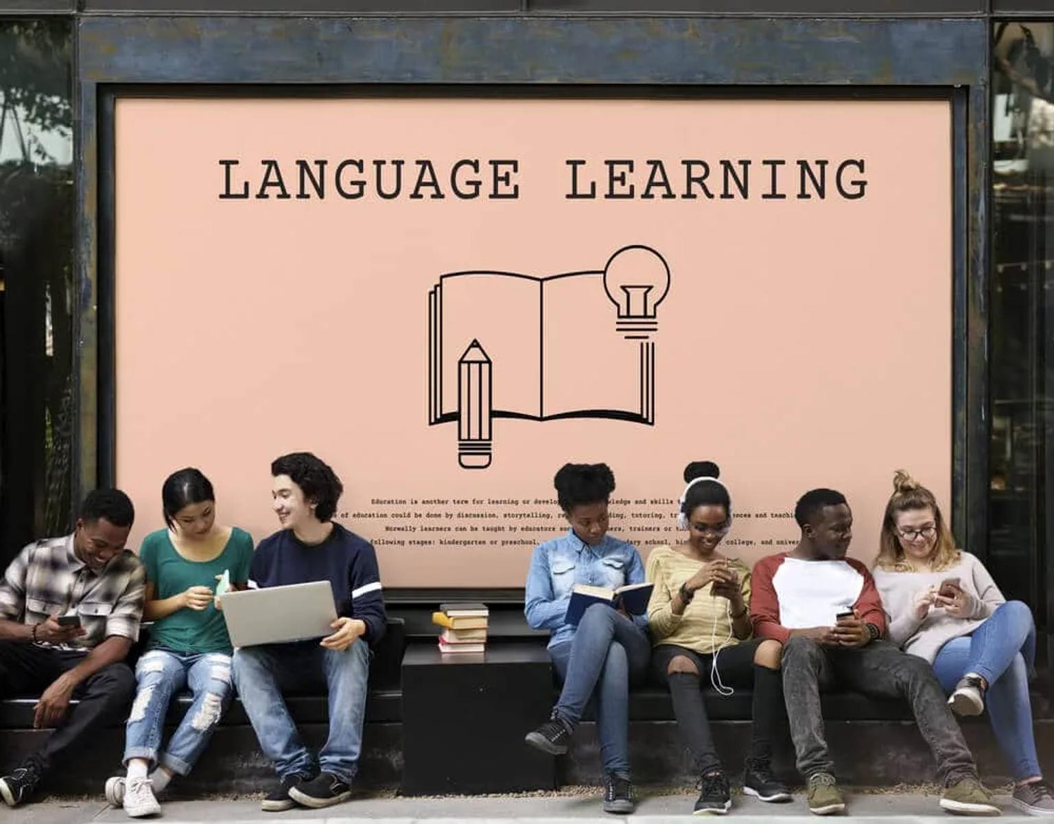 varios jovens sentados em frente a um placar sobre o ensino de linguas