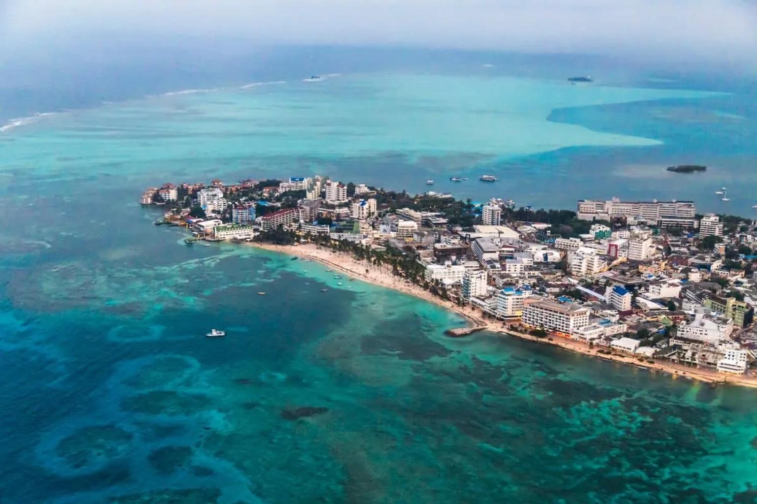 Vista aérea de San Andrés, con playas y edificios junto al mar turquesa.