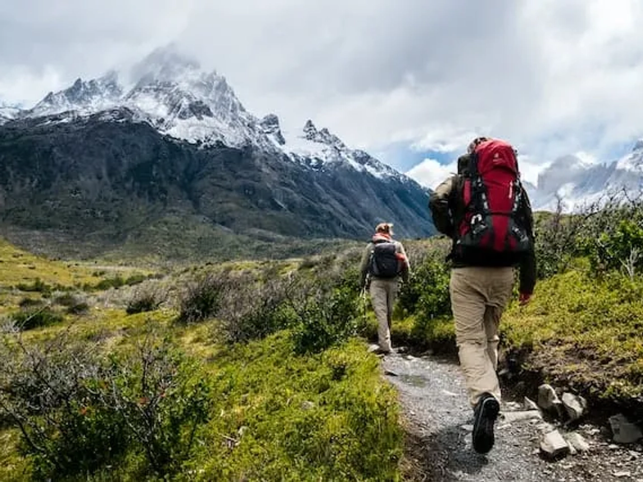 dois mochileiros a andar por montanha