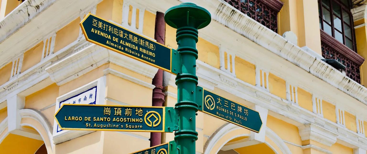 Placa de sinalização em Macau, indicando ruas e pontos turísticos importantes.