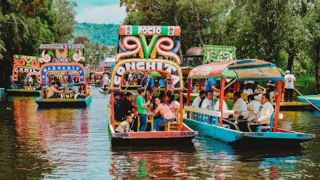 barcos coloridos com pessoas em Xochimilco no México