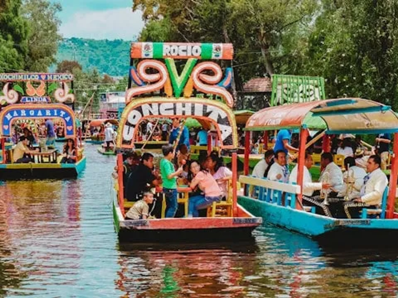 barcos coloridos com pessoas em Xochimilco no México