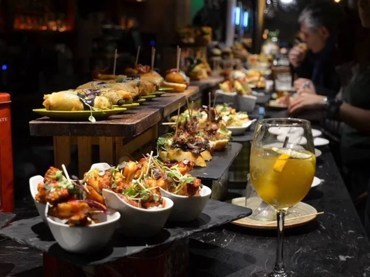 Mesa con variedad de pintxos y una bebida en un bar de Bilbao.
