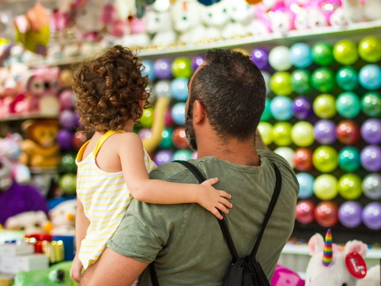 Padre comprando juguetes a su hija con una tarjeta de crédito sin vinculación a un seguro de vida.