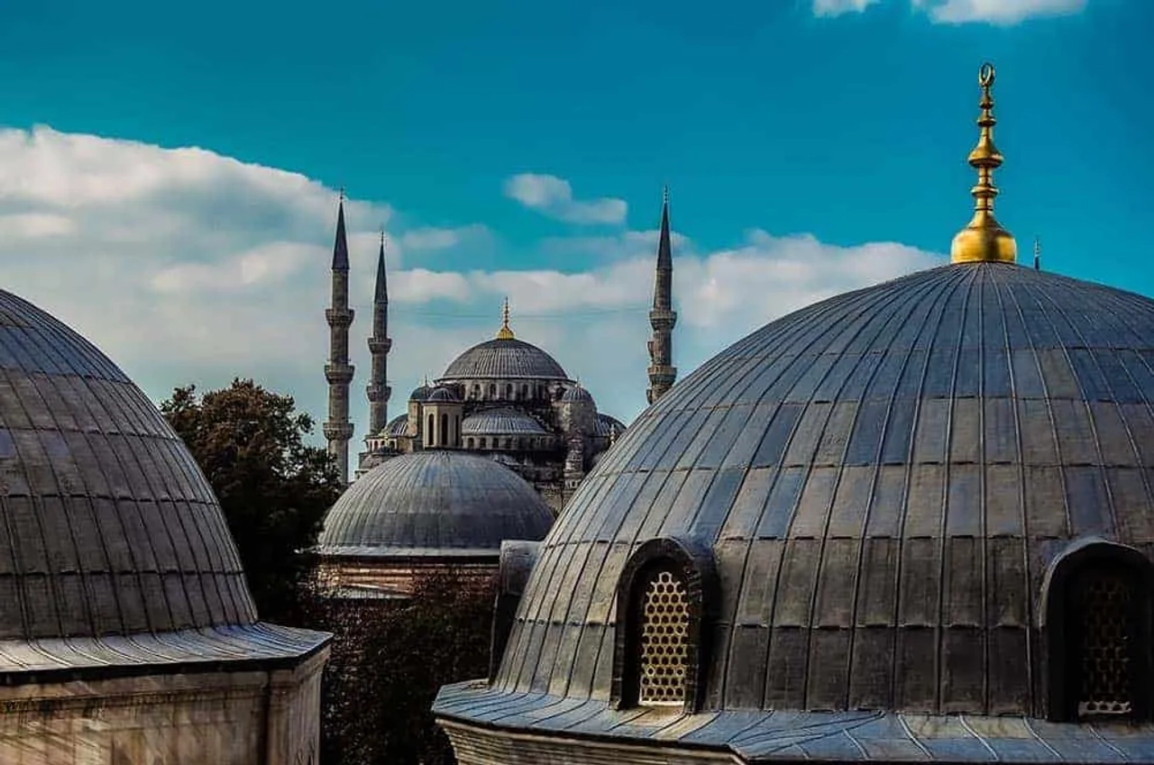 Vista de cúpulas e minaretes de mesquitas em Istambul sob céu azul.