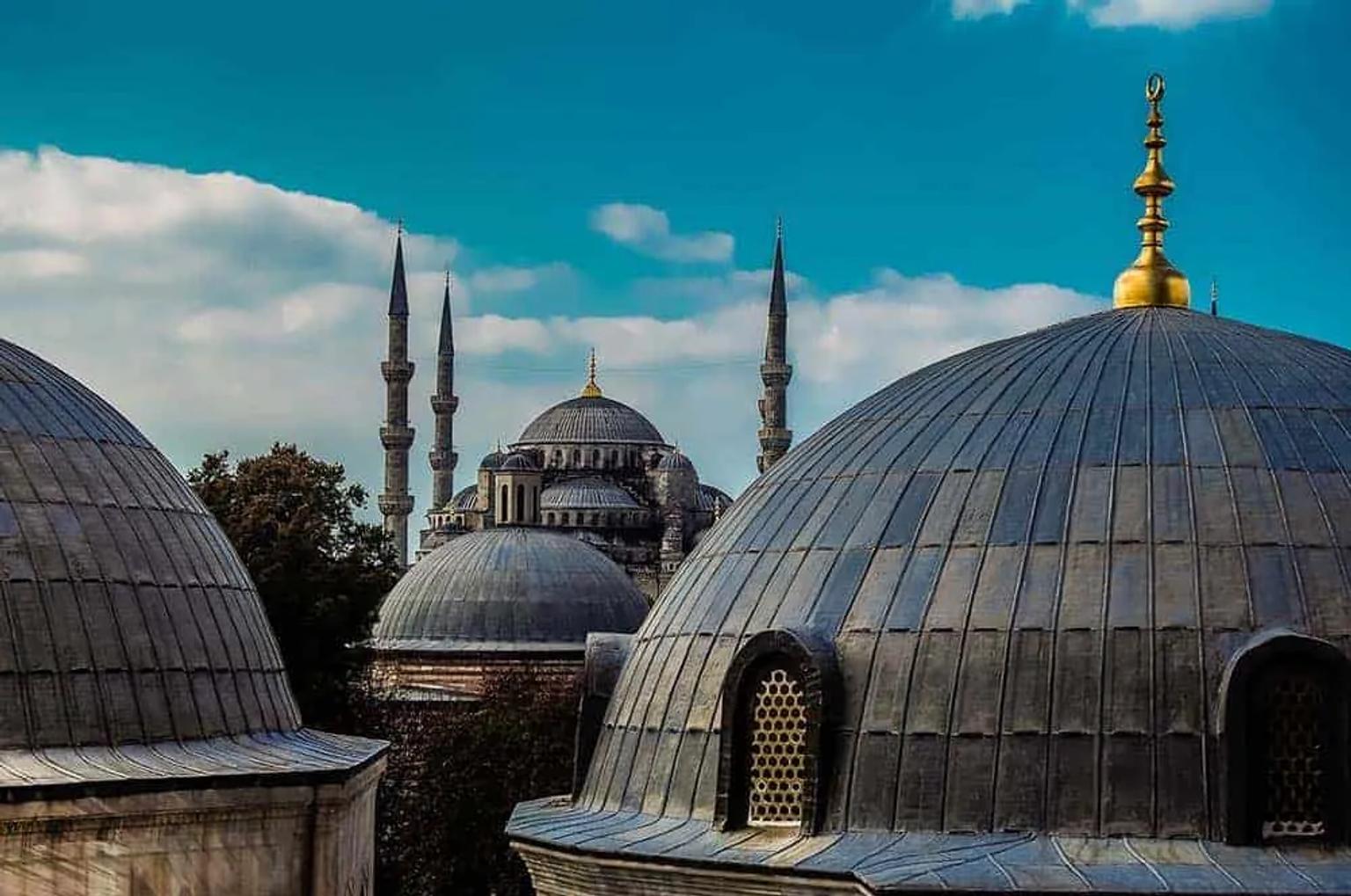 Vista de cúpulas e minaretes de mesquitas em Istambul sob céu azul.
