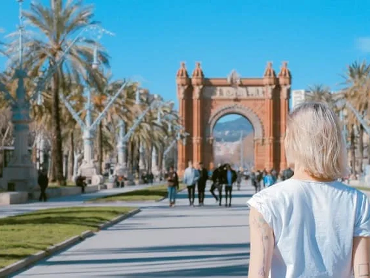 senhora a observar o arco do triunfo ao longe em bracelona