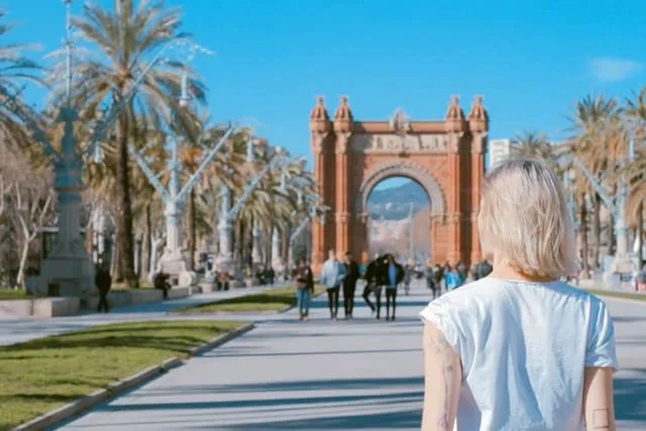 senhora a observar o arco do triunfo ao longe em bracelona