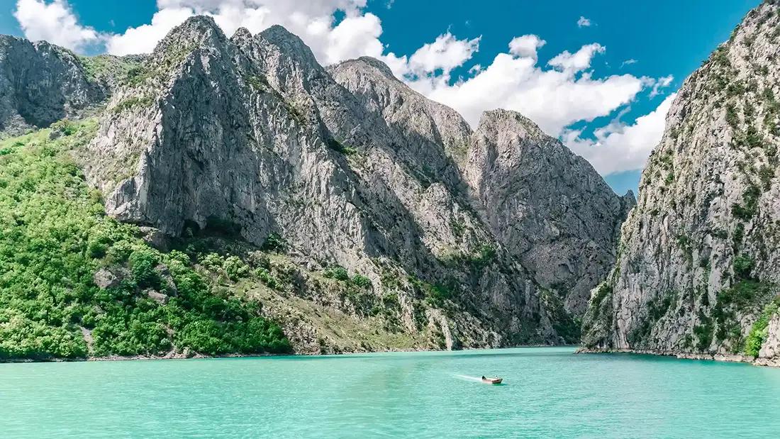 un barco navegando por un lago de albania