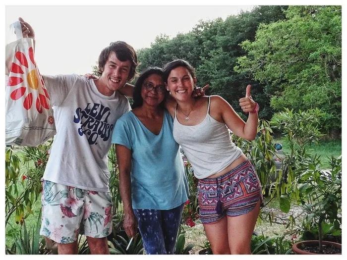 Tres amigos sonrientes posan juntos en un entorno natural.