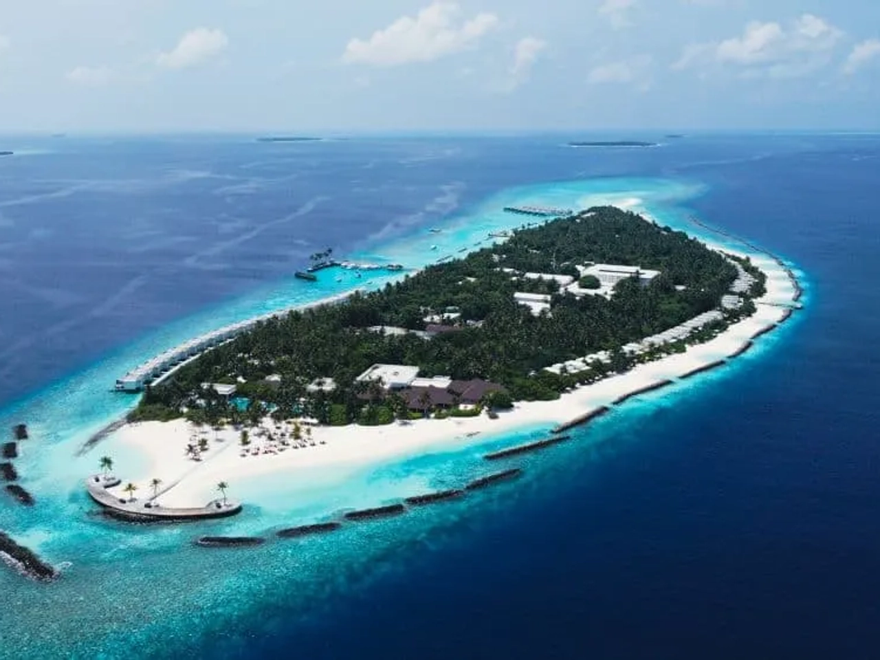 Isla tropical en Maldivas con playas de arena blanca y aguas turquesas.