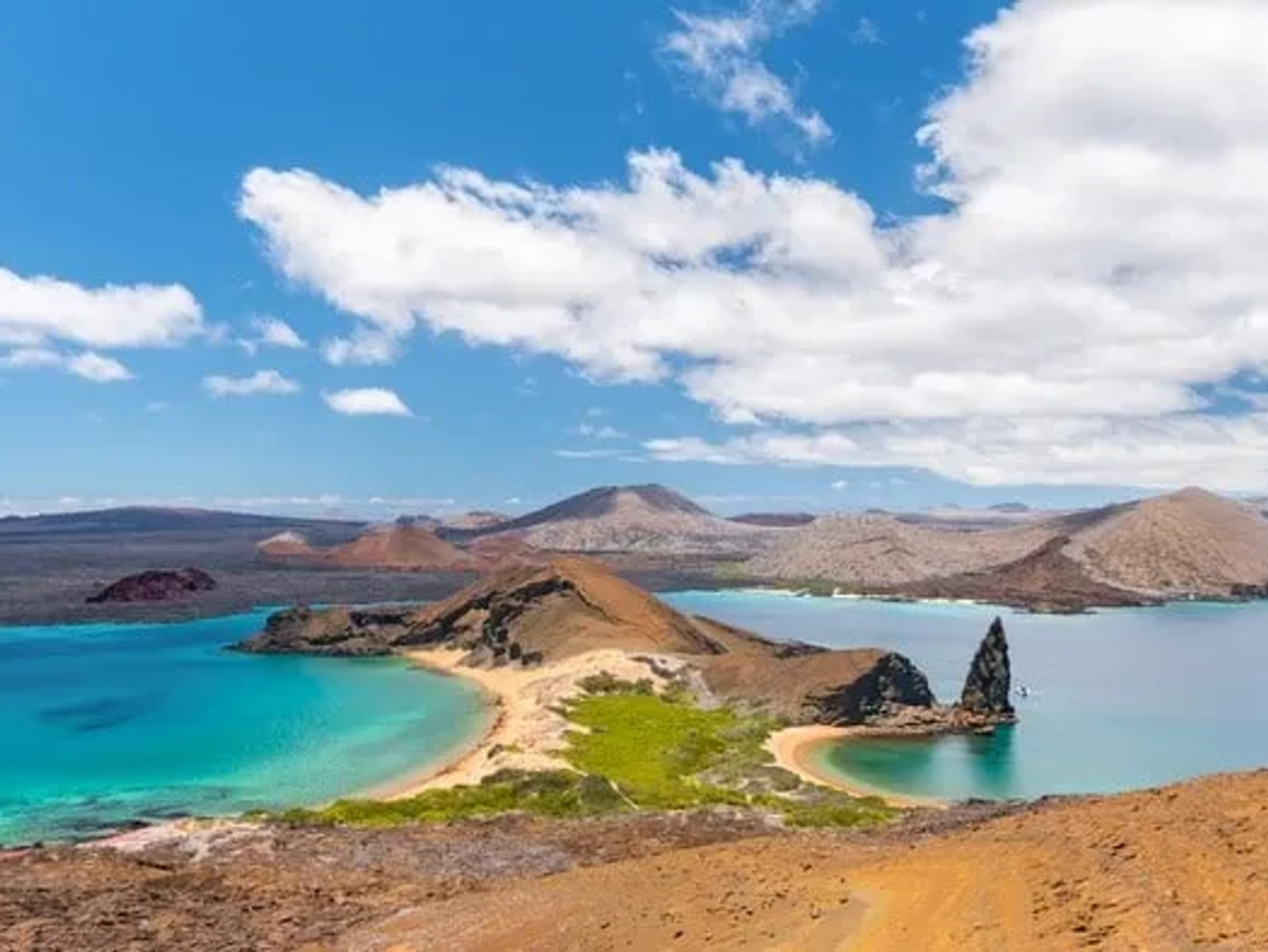 Vista panorámica de las Islas Galápagos con aguas turquesas y paisajes volcánicos.
