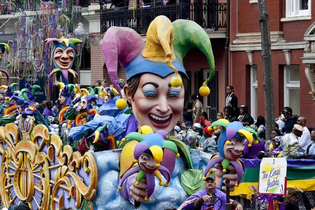 Desfile de Carnaval com grandes fantasias coloridas e personagens festivos.
